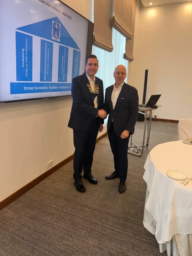 Presidential handover at the RCMI Annual General Meeting, with the AGM 2026 presentation behind the participants